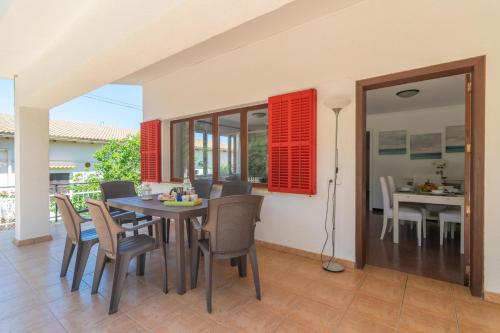 a dining room with a table and chairs at Es Pins in Font de Sa Cala