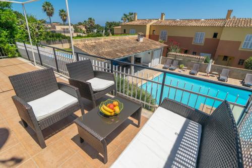 a balcony with chairs and a bowl of fruit on a table at Es Pins in Font de Sa Cala