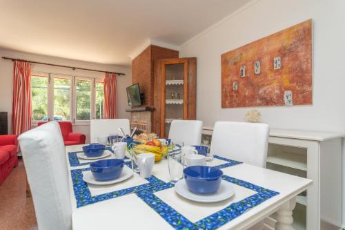 a dining room with a table with blue dishes on it at Es Pins in Font de Sa Cala