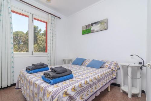 a bedroom with a bed with two towels on it at Es Pins in Font de Sa Cala