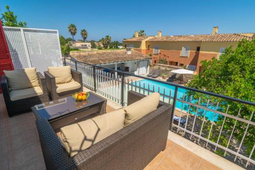 a balcony with chairs and a table and a pool at Es Pins in Font de Sa Cala