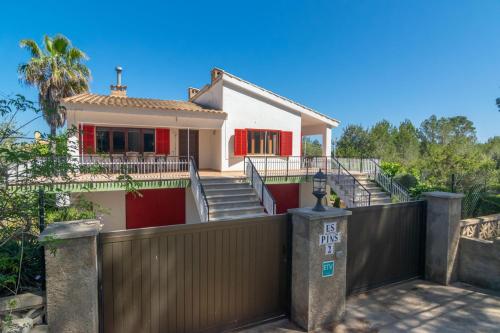 a house with a gate and a fence at Es Pins in Font de Sa Cala