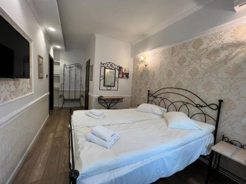 a bedroom with a bed with two towels on it at Hotel Boutique Cathedral Plaza Residences room for rent downtown in Bucharest