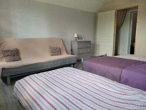 ein Schlafzimmer mit 2 Betten und einer Kommode darin in der Unterkunft La maison de lavande in Laon