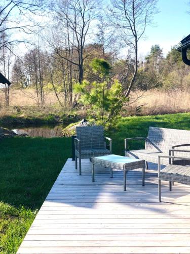 a group of benches sitting on a boardwalk at Pärli puhkemaja / Pearl riverside house in Pudisoo