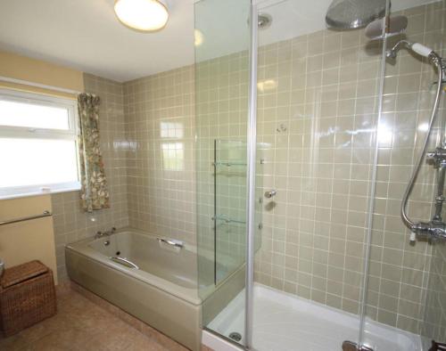a bathroom with a shower and a tub and a sink at Upper Gren in Polzeath