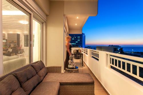 a living room with a couch on a balcony at Unique Sea & Sunset Residence in Ixia
