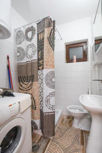 Un baño con lavadora y lavabo. en Weekendaya, en Kladovo