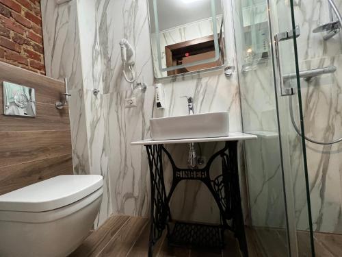 a bathroom with a sink and a toilet and a shower at Hotel Boutique Cathedral Plaza Residences room for rent downtown in Bucharest