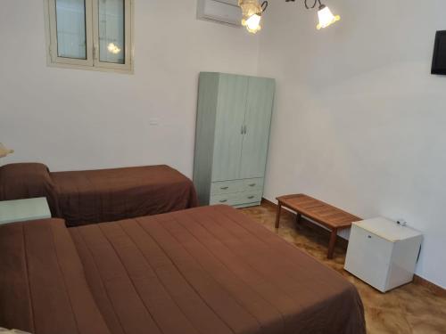 1 Schlafzimmer mit 2 Betten, einem Schrank und einer Bank in der Unterkunft Controvento in Porto Cesareo