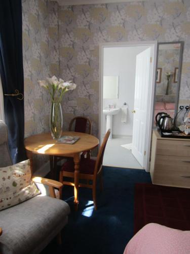 un jarrón de flores sobre una mesa en una habitación en Athollbank Guest House, en Dundee