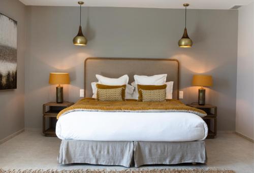 a bedroom with a large bed with two lamps at Domaine de Montine Chambres de Charme in Grignan