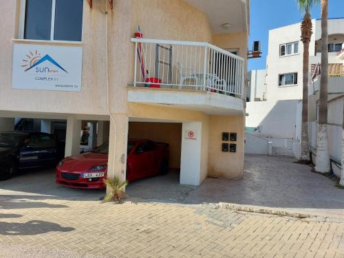 a red car parked in front of a building at Downtown Agia Napa in Ayia Napa