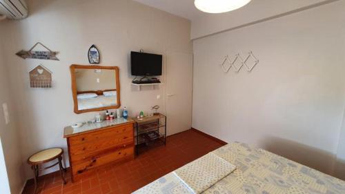 a bedroom with a bed and a dresser and a mirror at Nea Styra seafront apartment with stunning view in Nea Stira