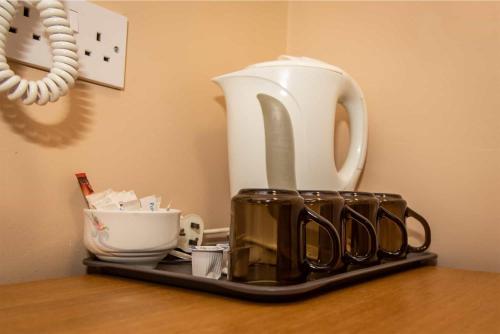 a tray with a tea kettle and cups on a table at The Beechfield Hotel in Blackpool
