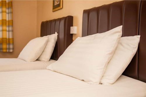 a bed with white pillows on top of it at The Beechfield Hotel in Blackpool