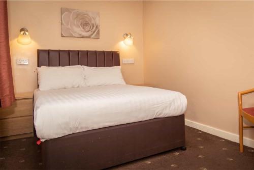 a bedroom with a large bed with white sheets at The Beechfield Hotel in Blackpool
