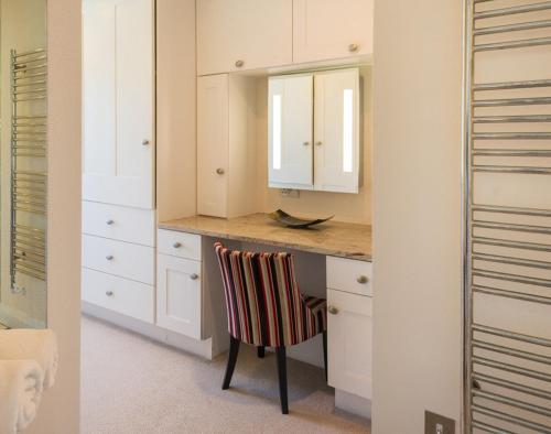 Una cocina con una encimera con una silla y un espejo. en Egloskerry, en Wadebridge