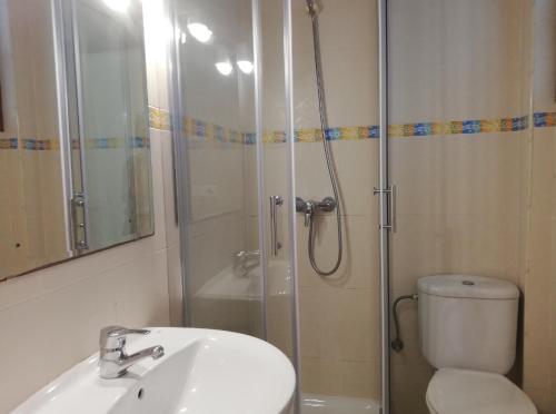 a bathroom with a shower and a sink and a toilet at Apartamentos Colon in Salou