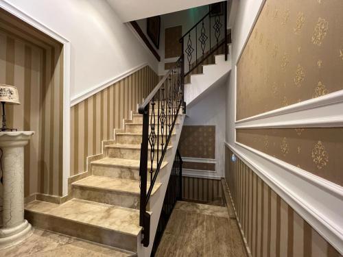 a staircase in a house with brown and white walls at Hotel Boutique Cathedral Plaza Residences room for rent downtown in Bucharest