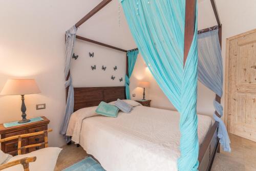 a bedroom with a bed with blue drapes at Casa Elvi in Arzachena