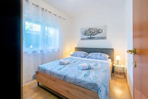 a bedroom with a bed with two towels on it at Modern apartment with private pool in Bibinje