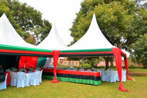 a tent with chairs and tables in a field at MAKERERE UNIVERSITY GUEST HOUSE in Kampala