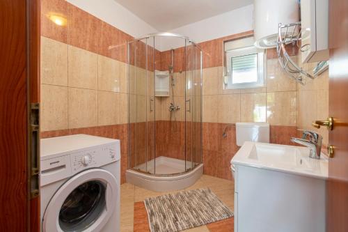 a bathroom with a washing machine and a sink at Modern apartment with private pool in Bibinje
