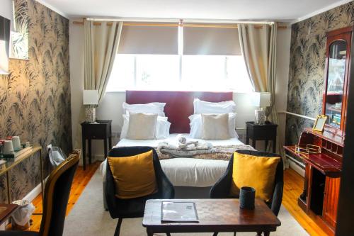 a bedroom with a bed and a table and chairs at The Bank Hotel & Bistro in Hastings