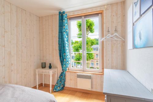 sypialnia z łóżkiem i oknem w obiekcie Un air de vacances w mieście Honfleur
