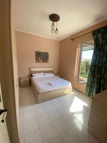 - une chambre avec un lit blanc et une fenêtre dans l'établissement Vollga Promenade Lovely 2 bedroom Apartment, à Durrës
