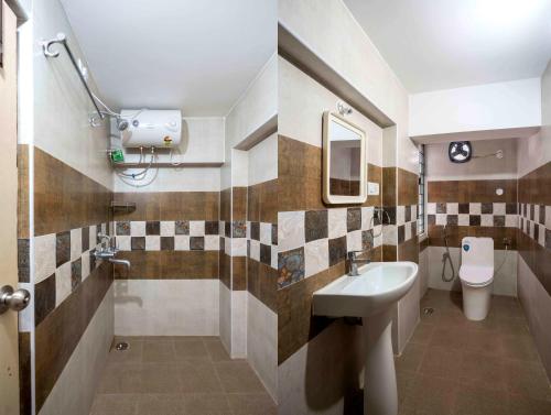 a bathroom with a sink and a toilet at Hotel Brundavan Homes in Hyderabad
