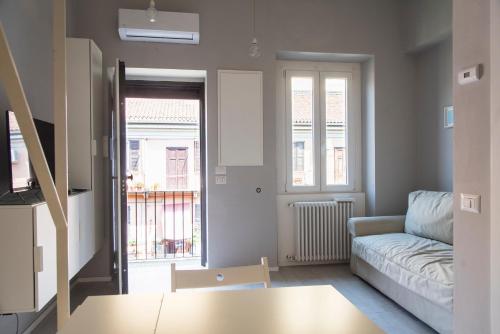 uma sala de estar com um sofá e uma janela em YouHosty - Custodi 12 em Milão