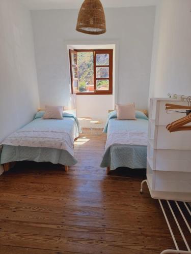 - une chambre avec 2 lits et une fenêtre dans l'établissement Km00 centro, à Vallehermoso