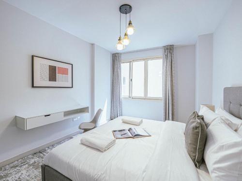 Habitación blanca con cama y ventana en Stylishly Decorated Spacious 3 Bed next to Metro en Dubái
