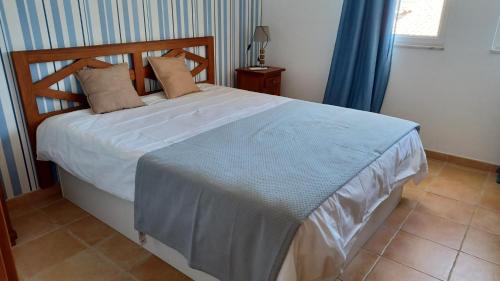 a bedroom with a large bed with a blue blanket at Quinta Velha 22 in Tavira