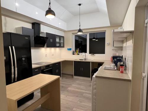 a kitchen with black and white cabinets and a counter at Welsh Homestay in Pembroke Dock