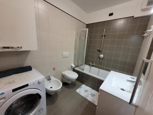a bathroom with a washing machine and a toilet at RIVA DEL GARDA APART in Riva del Garda