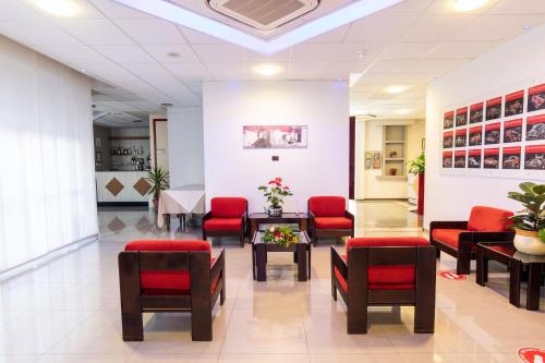 a waiting room with red chairs and a table at XXV APRILE Casa per Ferie in Albenga