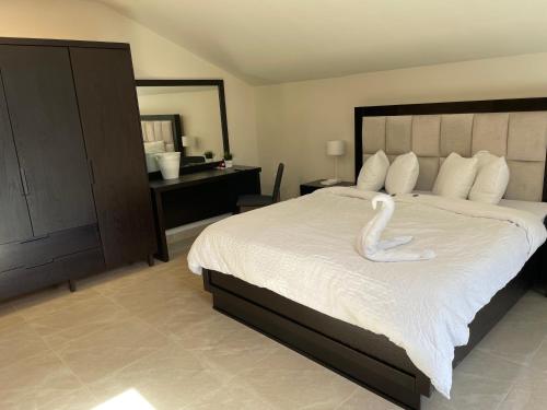 Un dormitorio con una cama grande con un cisne. en Mizirawi Historic Hotel en Ramallah