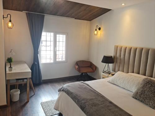 a bedroom with a bed and a desk and a window at Casa Lorenzo Bogota in Bogotá