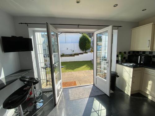 a kitchen with a door open to a yard at Paignton Place in Marldon