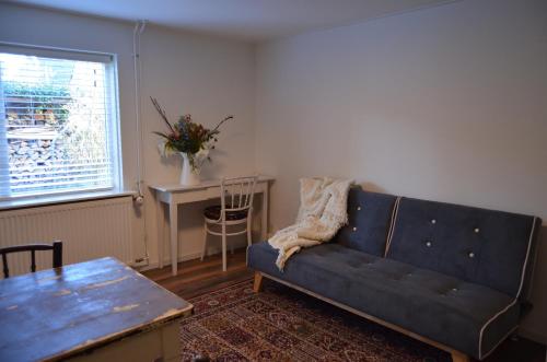 a living room with a blue couch and a table at Hotel De Waag in Bergen