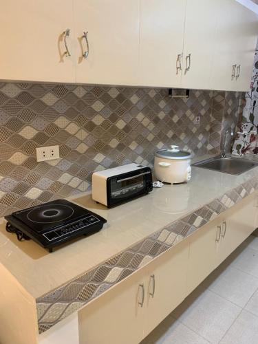a kitchen counter with a microwave and a sink at JORA Studio Apartment 1-B in Dagupan