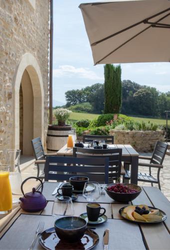 a table with bowls of food on a patio at Domaine de Montine Chambres de Charme in Grignan