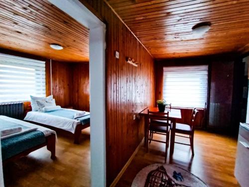 a room with a bed and a table and a bed and a table and chair at Apartments "FERMAN" Visoko in Visoko