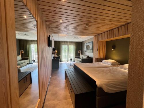 a bedroom with a large bed and a living room at ´t Wapen van Marion in Oostvoorne