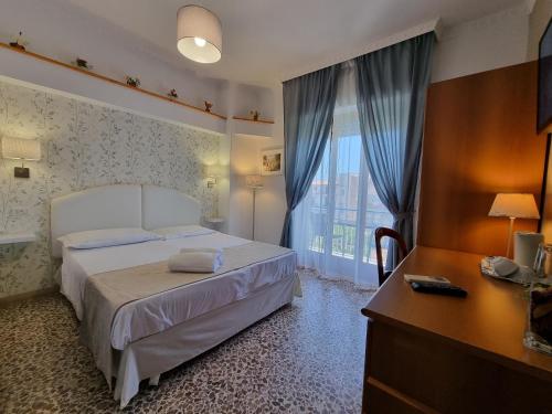 a bedroom with a bed and a desk and a window at Villa Susy Relais in Sant'Agnello