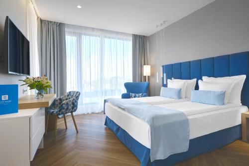 Viva Mare Beach Hotel by Santa Marina في سوزوبول: غرفة نوم مع سرير كبير مع اللوح الأمامي الأزرق