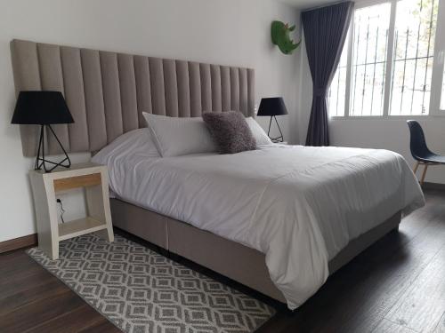a bedroom with a large bed and a large window at Casa Lorenzo Bogota in Bogotá
